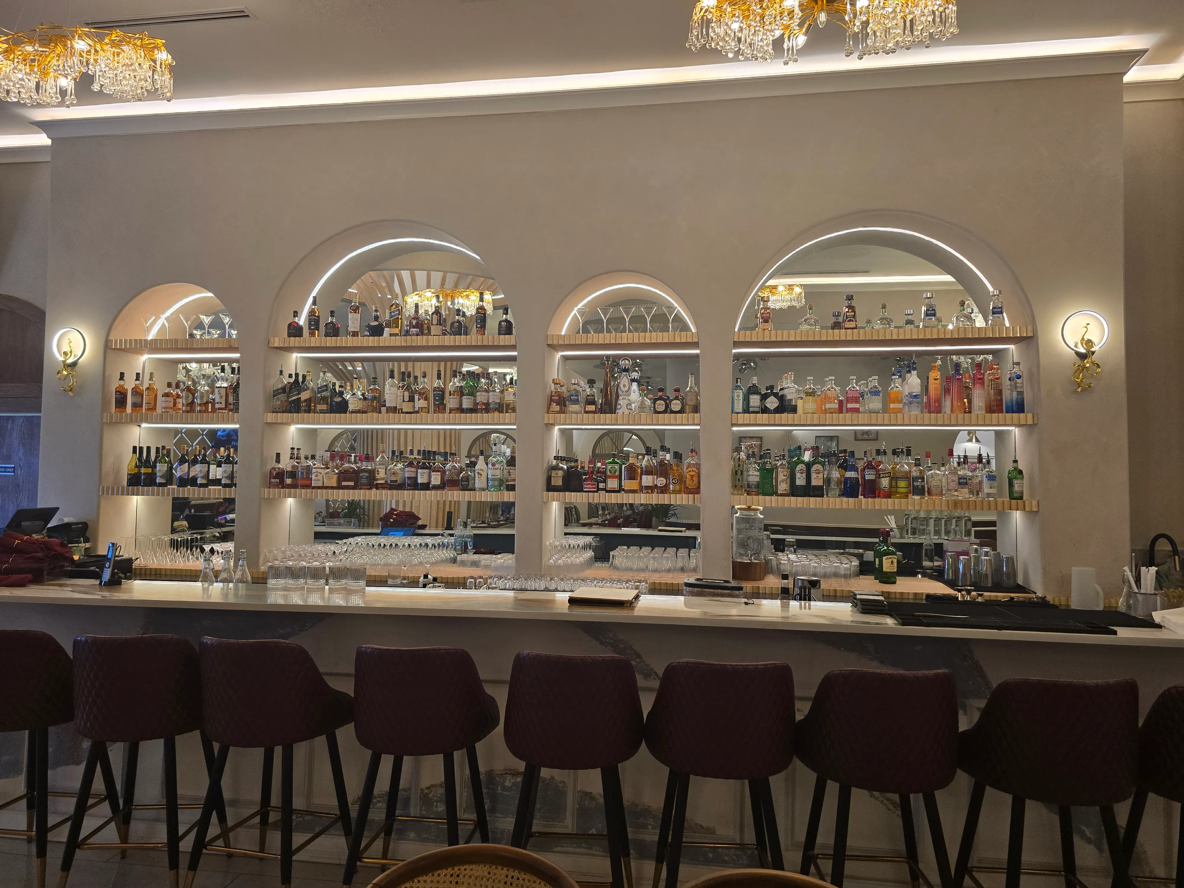 Elegant backlit arched bar shelves at Ghazal Fine-Dine Restaurant, Edmonton