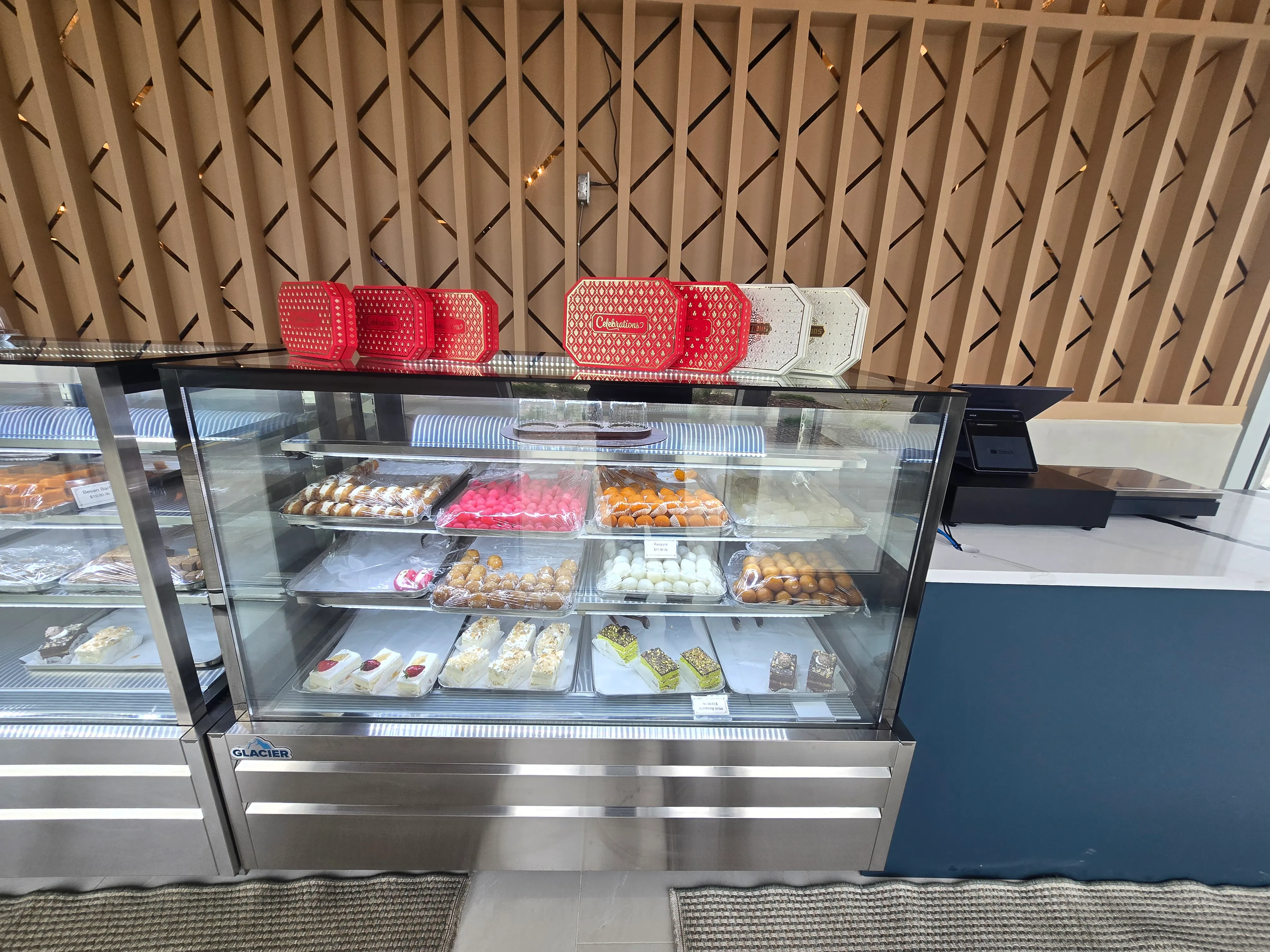 Trays of traditional South Asian mithai in the sweet-house display at Ghazal Edmonton